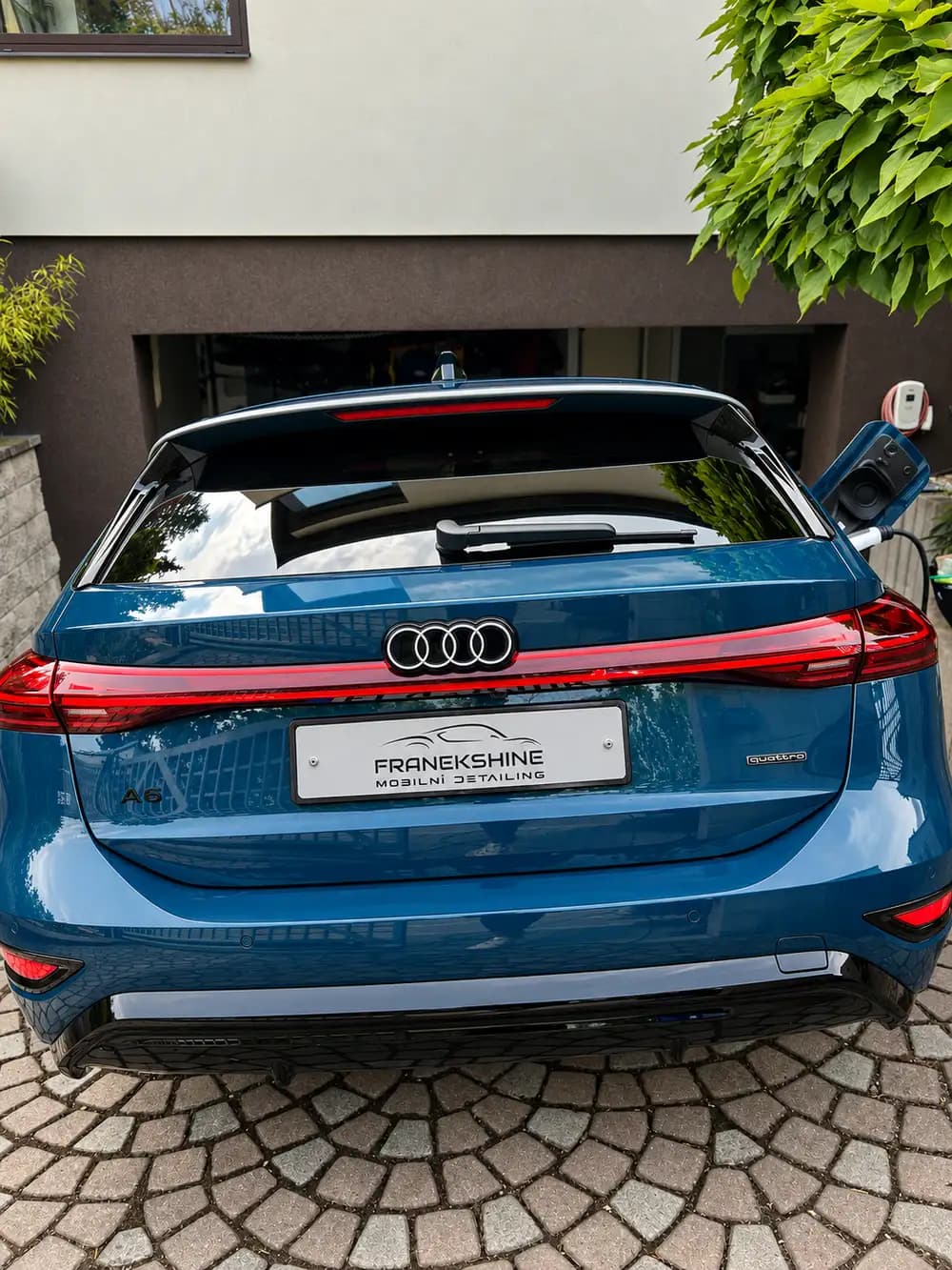 Zadní pohled shora na modré Audi A6 Avant s logem quattro