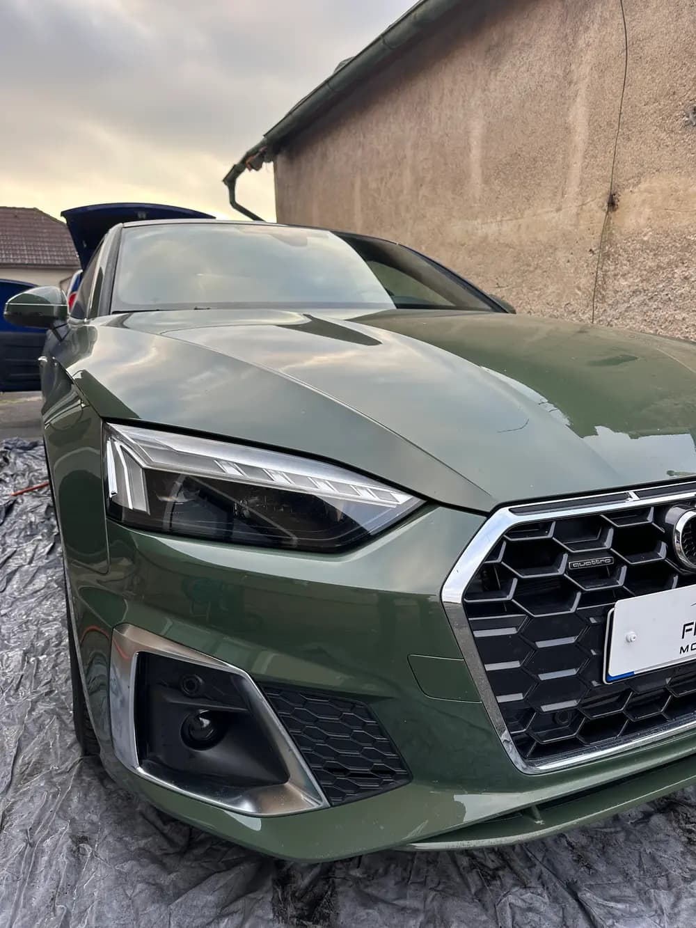 Zelené Audi A5 s předním nárazníkem během přípravy na ochranu laku