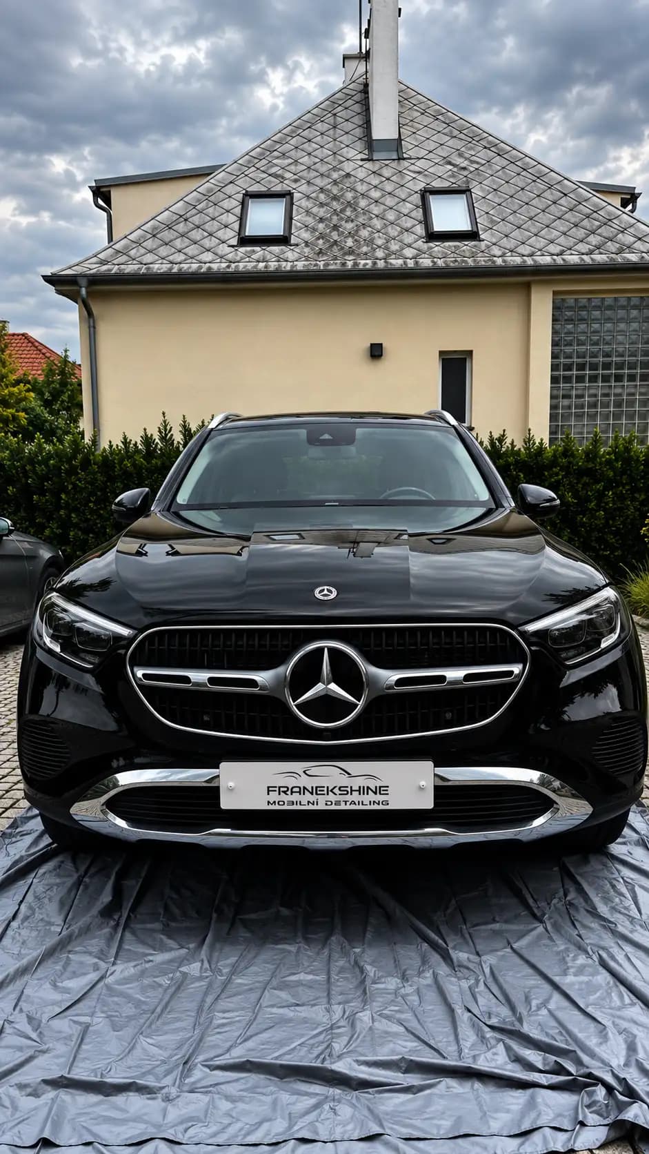 Černý Mercedes GLC zepředu symetricky na ochranné plachtě