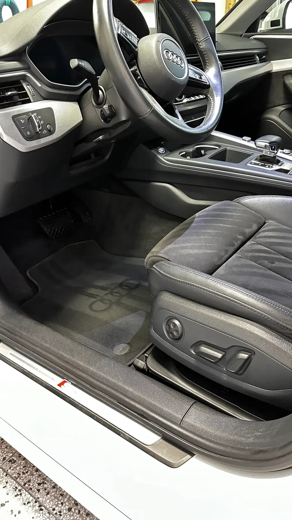 Řidičský prostor Audi s volantem a středovou konzolí po detailingu