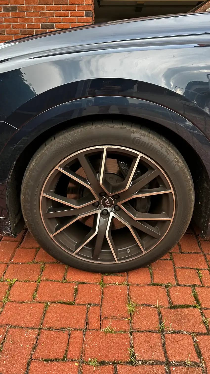 Detail kola Audi s dvoubarevnými loukoťmi a červeným třmenem S