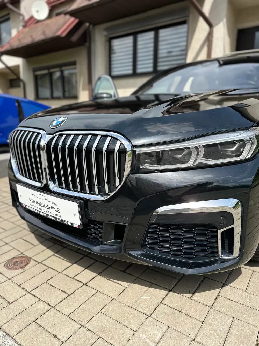 Naleštěné černé BMW X7 s hlubokým leskem laku na příjezdové cestě