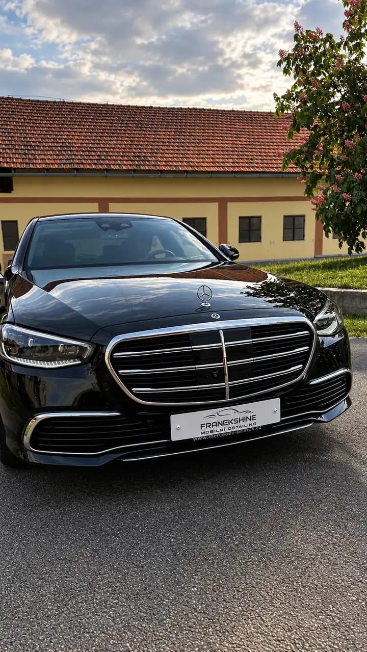 Tmavý Mercedes S-Class zepředu před rodinným domem po detailingu